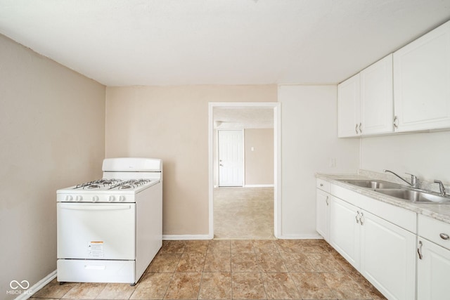 kitchen featuring sink, white gas range oven, and white cabinets