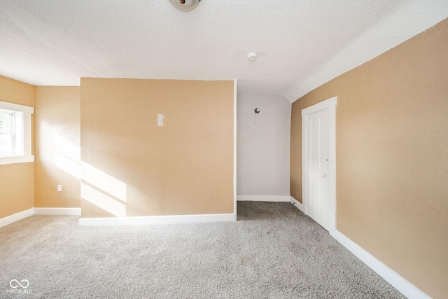 carpeted empty room featuring a textured ceiling