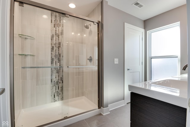 bathroom featuring vanity, tile patterned floors, and walk in shower