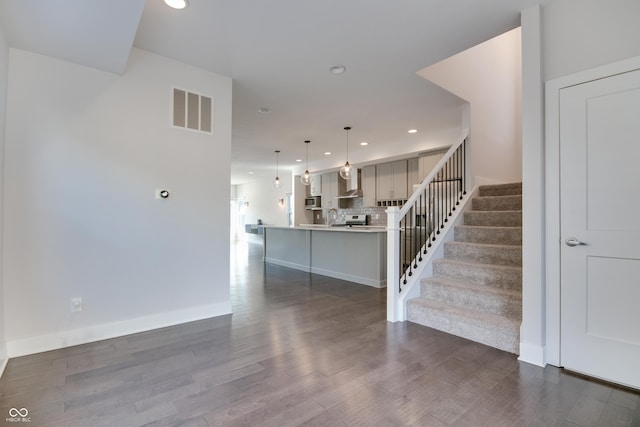 stairway featuring wood-type flooring and sink