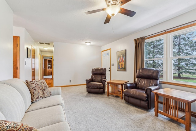 living room with light carpet, a textured ceiling, and ceiling fan