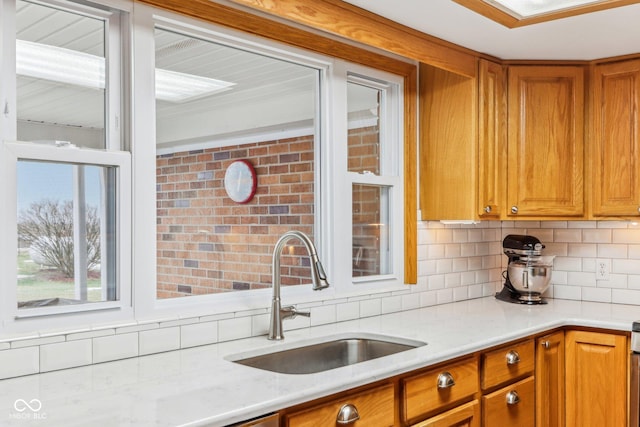 kitchen featuring tasteful backsplash, sink, and light stone counters