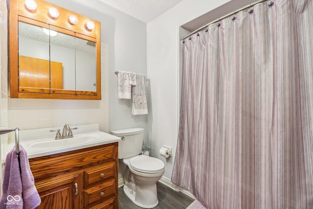 bathroom featuring vanity, wood-type flooring, toilet, and a textured ceiling