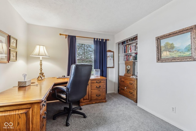 carpeted office space featuring a textured ceiling