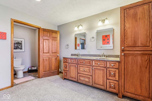 bathroom featuring vanity, toilet, and a textured ceiling