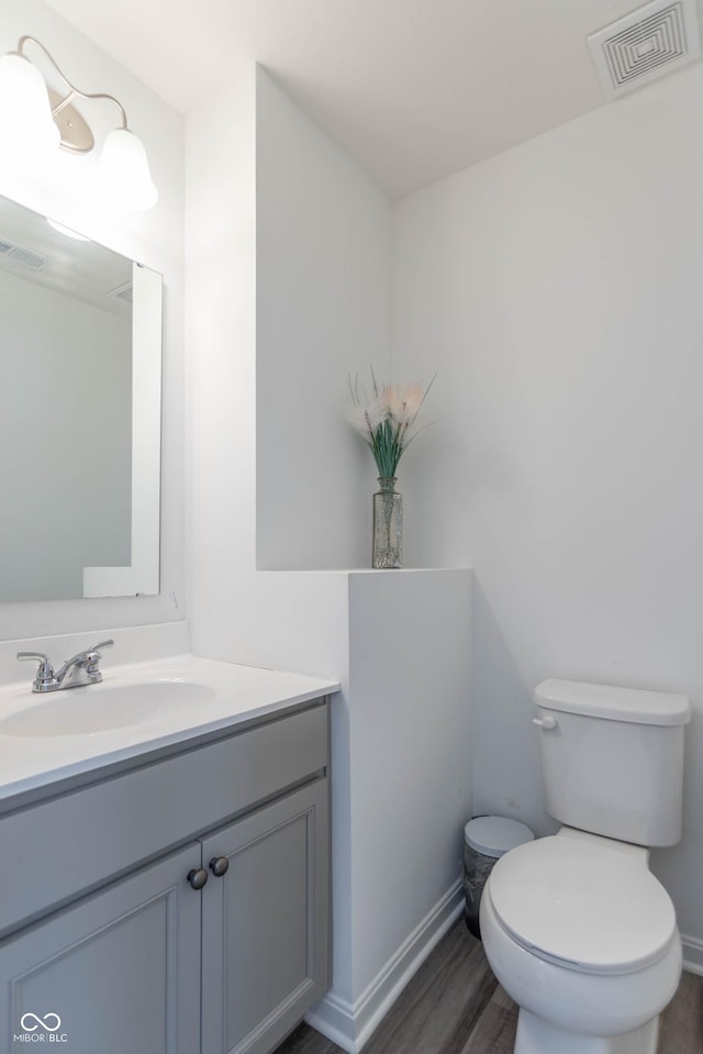 bathroom with vanity, hardwood / wood-style floors, and toilet