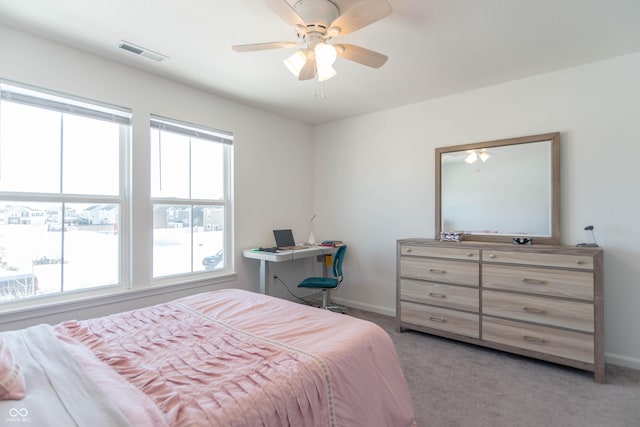 bedroom featuring multiple windows, light colored carpet, and ceiling fan