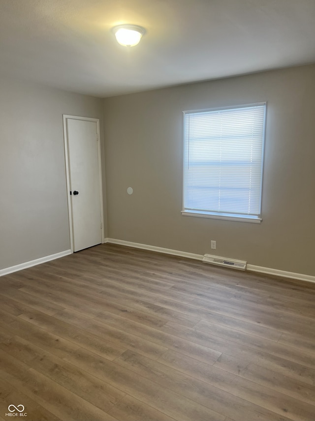 spare room featuring wood-type flooring