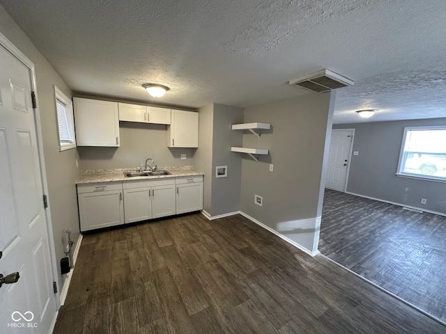 kitchen featuring white cabinetry, dark wood-type flooring, sink, and a textured ceiling