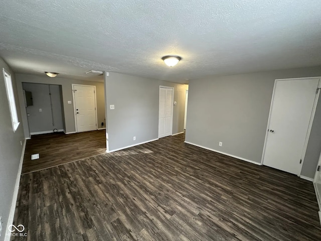 unfurnished room with dark hardwood / wood-style floors and a textured ceiling