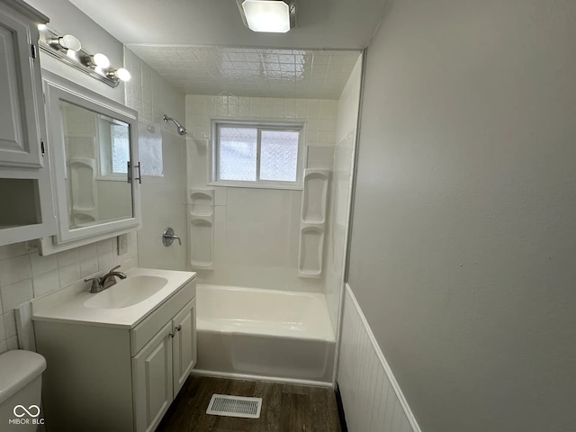 full bathroom featuring toilet, shower / bathing tub combination, vanity, hardwood / wood-style floors, and backsplash