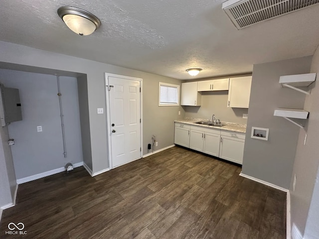 kitchen featuring dark hardwood / wood-style floors, sink, white cabinets, electric panel, and a textured ceiling