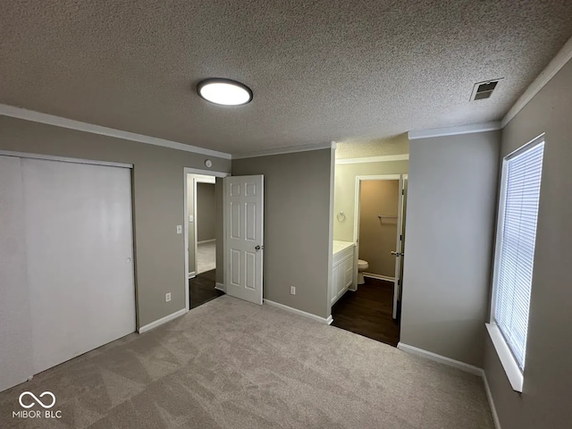 unfurnished bedroom featuring multiple windows, ornamental molding, connected bathroom, and light carpet