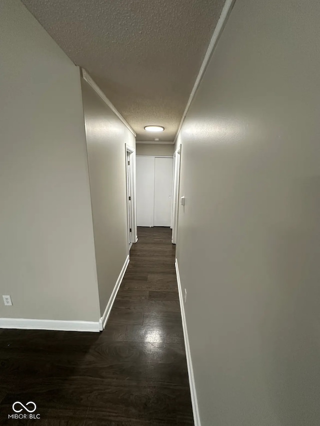 hall with dark wood-type flooring and a textured ceiling