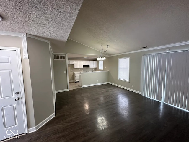 unfurnished living room with dark wood-type flooring, an inviting chandelier, vaulted ceiling, and a textured ceiling