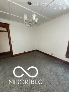 unfurnished dining area with a notable chandelier and carpet floors