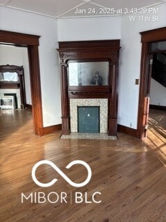 unfurnished living room with ornamental molding and hardwood / wood-style floors