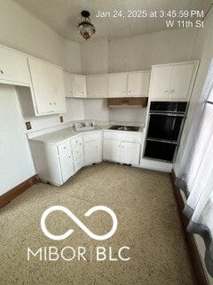 kitchen with white cabinetry, sink, and black appliances