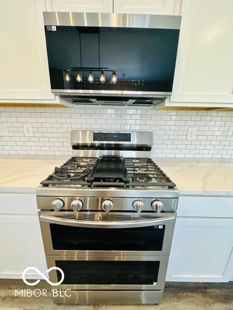 kitchen with light stone countertops, white cabinetry, and appliances with stainless steel finishes