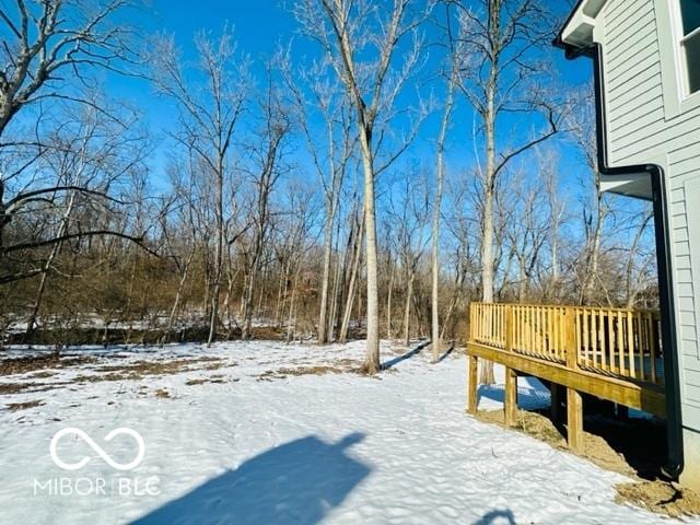 yard covered in snow with a deck