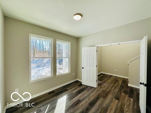 unfurnished room with dark wood-type flooring