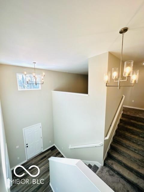 stairs with a notable chandelier and hardwood / wood-style floors