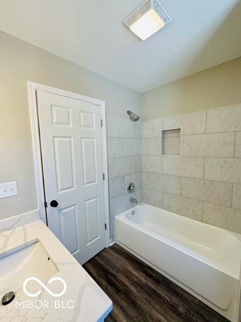 bathroom with vanity, hardwood / wood-style floors, and tiled shower / bath