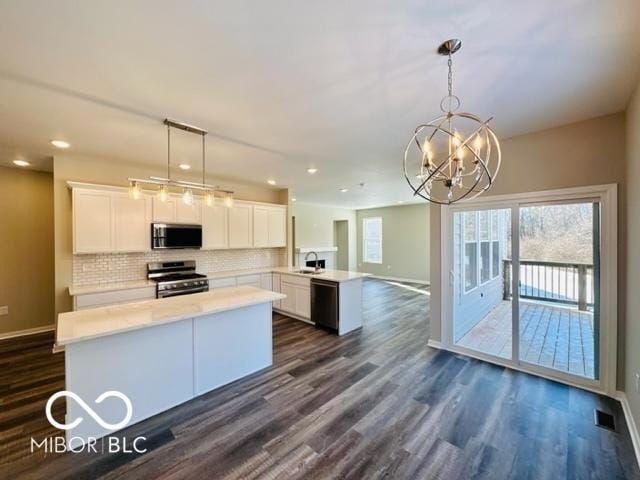 kitchen with white cabinetry, hanging light fixtures, and appliances with stainless steel finishes