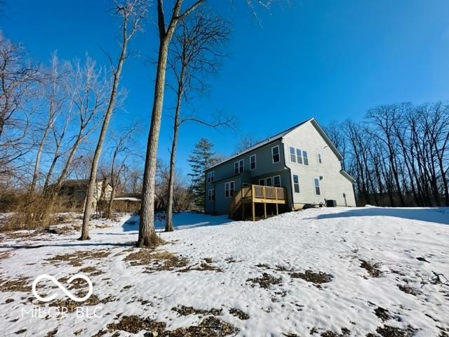 snow covered house with a wooden deck