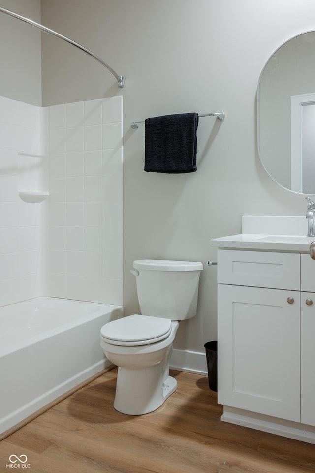 full bathroom featuring vanity, hardwood / wood-style flooring, toilet, and washtub / shower combination