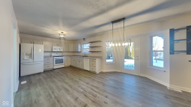 kitchen featuring pendant lighting, white appliances, plenty of natural light, and sink