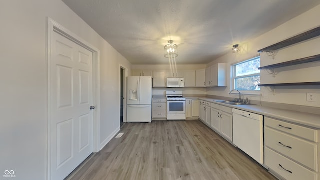 kitchen with white appliances, light hardwood / wood-style floors, sink, and white cabinets