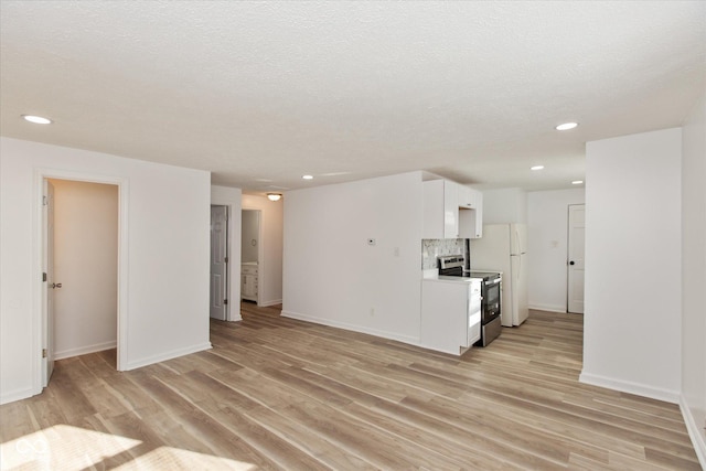 unfurnished living room with a textured ceiling and light wood-type flooring