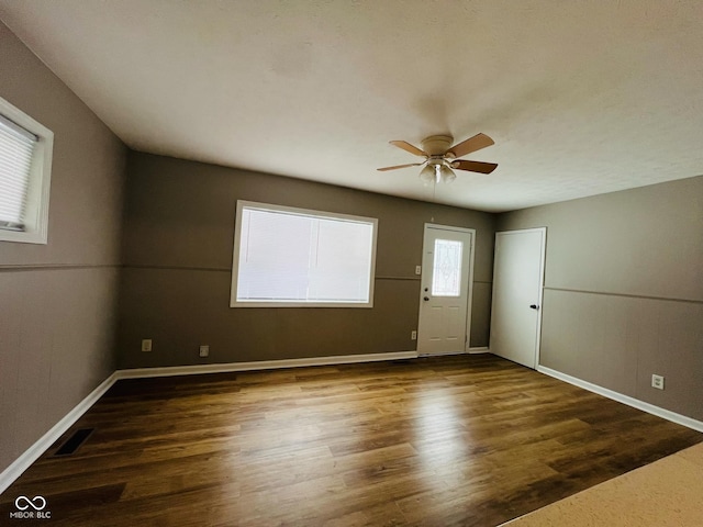 unfurnished room featuring dark hardwood / wood-style floors and ceiling fan