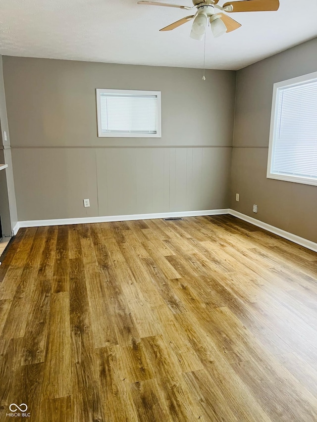 unfurnished room featuring ceiling fan, light hardwood / wood-style floors, and a healthy amount of sunlight