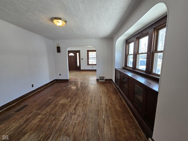 unfurnished living room featuring dark hardwood / wood-style floors and a textured ceiling