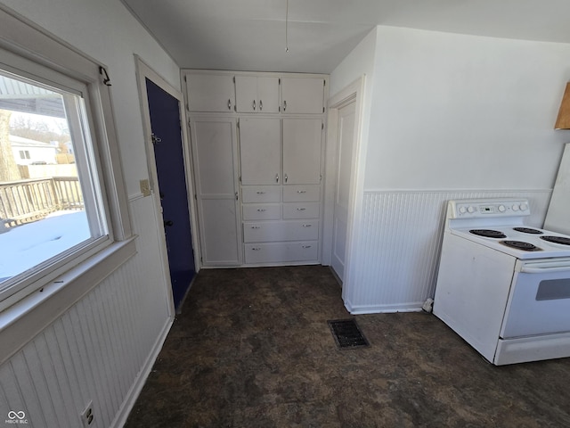 kitchen featuring plenty of natural light, white electric range oven, and white cabinets