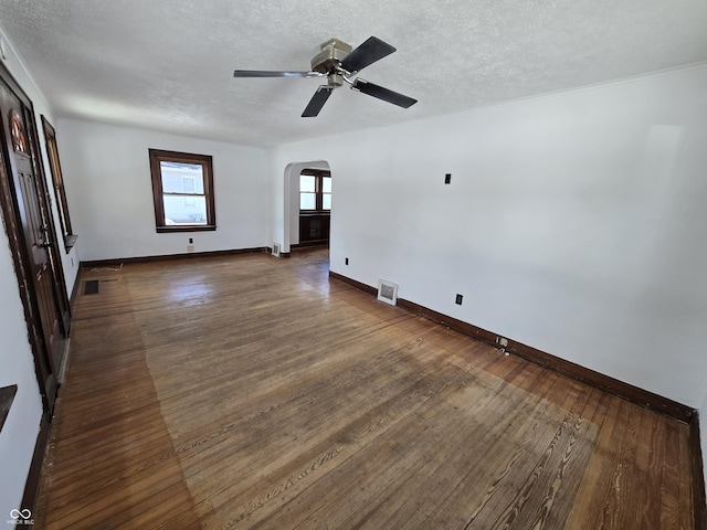 spare room with dark hardwood / wood-style floors, a textured ceiling, and ceiling fan