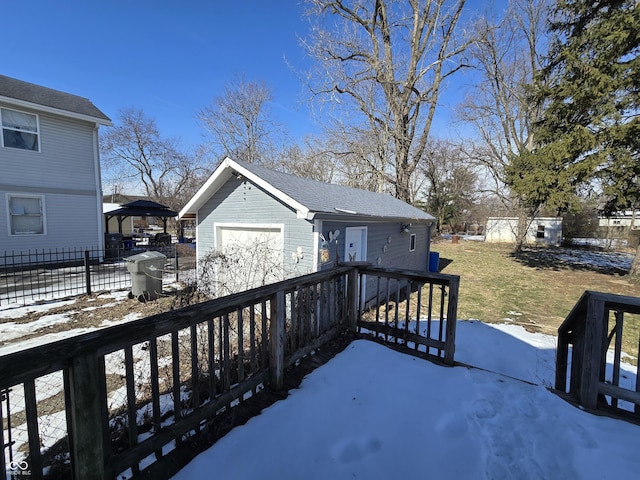 snow covered deck with a garage and an outdoor structure