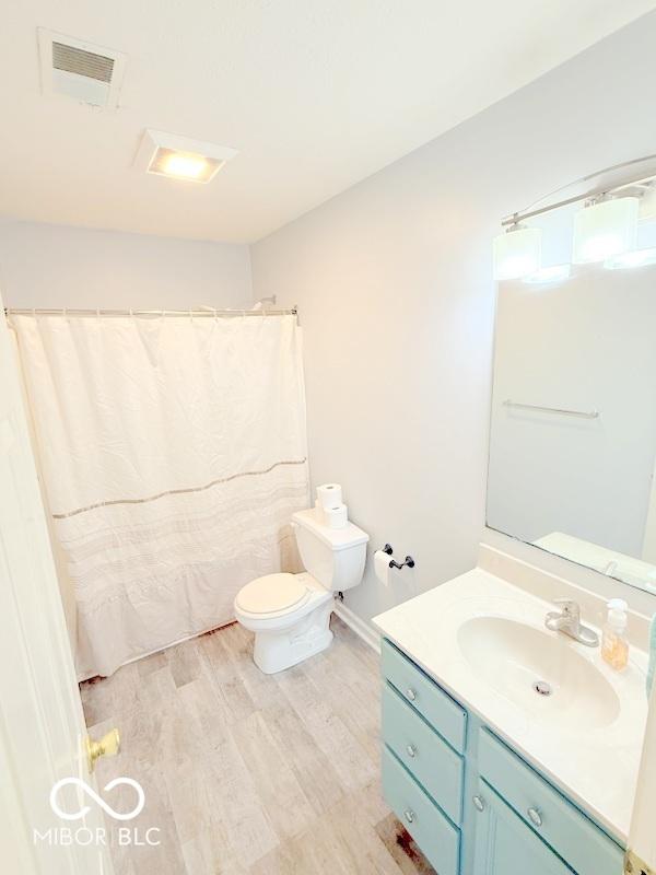 bathroom featuring vanity, hardwood / wood-style flooring, and toilet