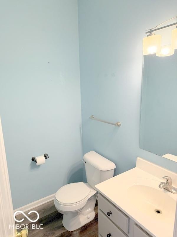 bathroom with hardwood / wood-style flooring, vanity, and toilet