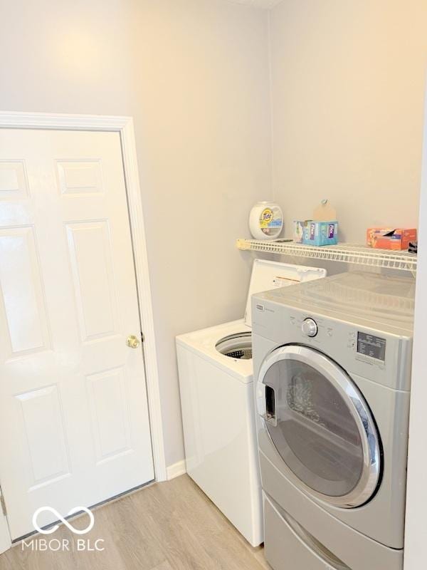 washroom featuring light hardwood / wood-style flooring and washer and dryer