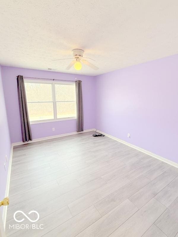 spare room with ceiling fan and light hardwood / wood-style flooring