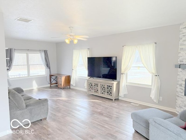 living room featuring ceiling fan and light hardwood / wood-style floors