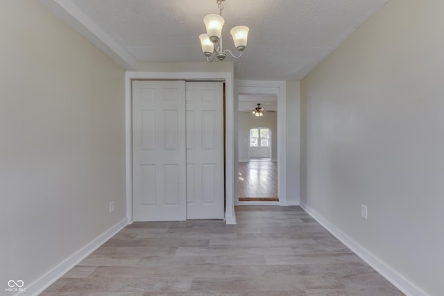 unfurnished bedroom with light hardwood / wood-style flooring, a textured ceiling, and a closet