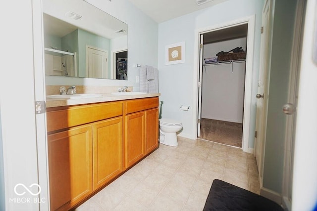 bathroom featuring vanity, an enclosed shower, and toilet