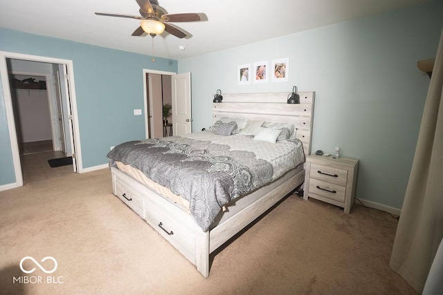 carpeted bedroom with a walk in closet, a closet, and ceiling fan