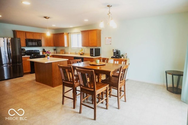 kitchen with decorative light fixtures, black appliances, a center island, and a chandelier