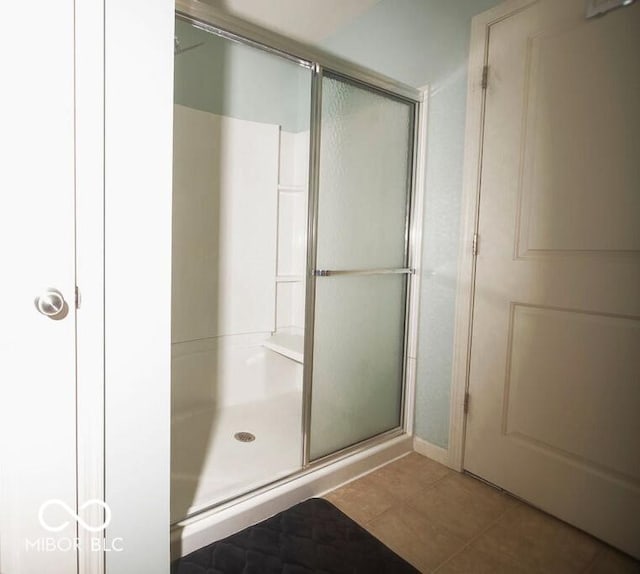 bathroom featuring an enclosed shower and tile patterned floors