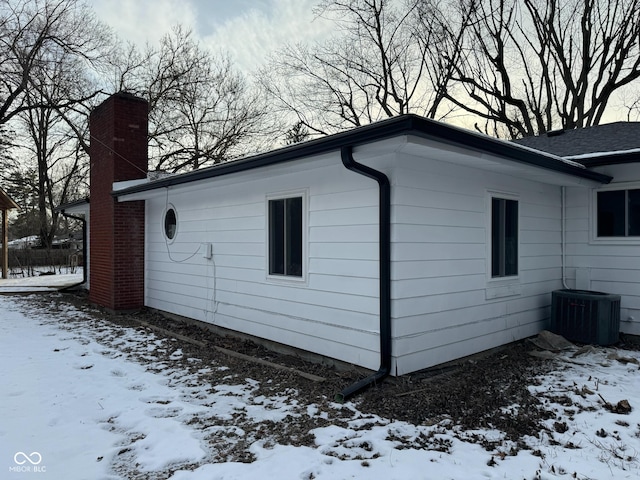 view of snow covered exterior featuring cooling unit